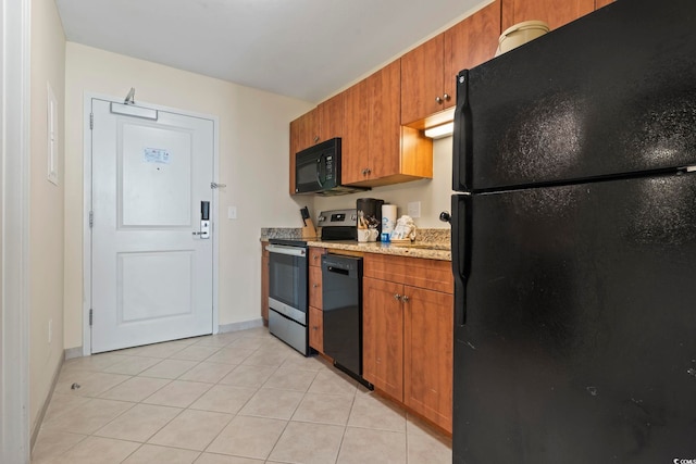 kitchen with black appliances, light tile patterned flooring, and light stone counters