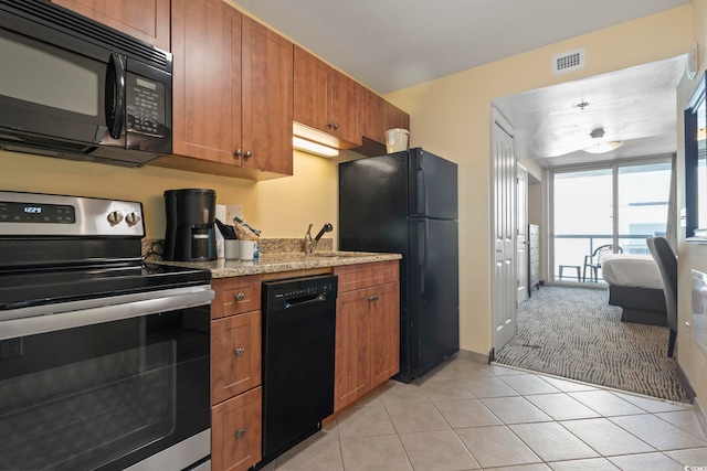 kitchen featuring black appliances, light tile patterned flooring, light stone countertops, and sink