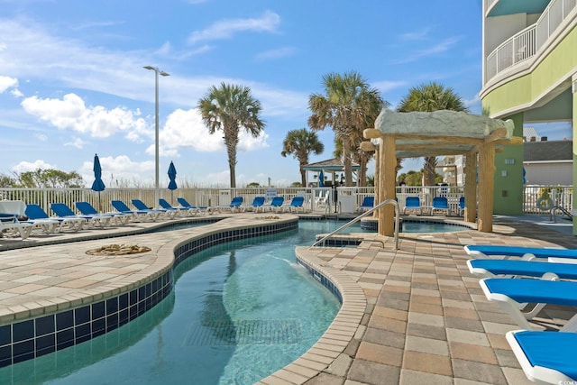 view of pool featuring a jacuzzi and a patio