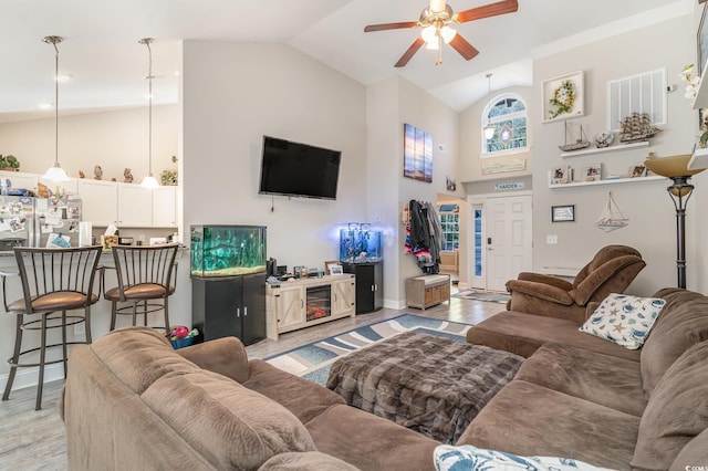 living room with ceiling fan, lofted ceiling, and light wood-type flooring