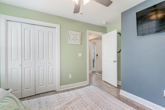 unfurnished bedroom with ceiling fan, light hardwood / wood-style flooring, and a closet