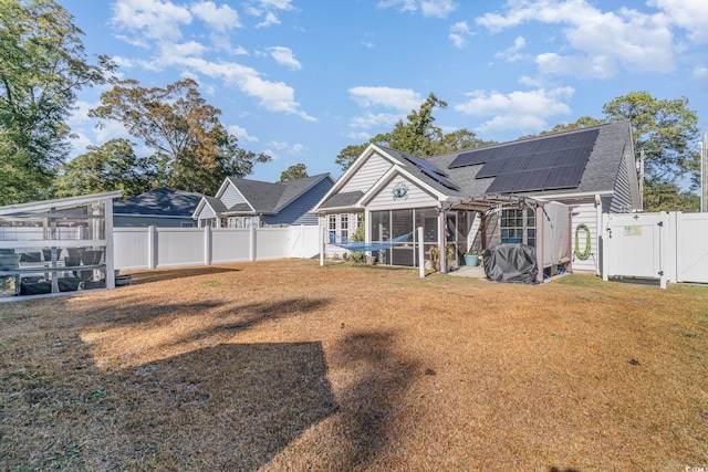 back of house with a sunroom and solar panels