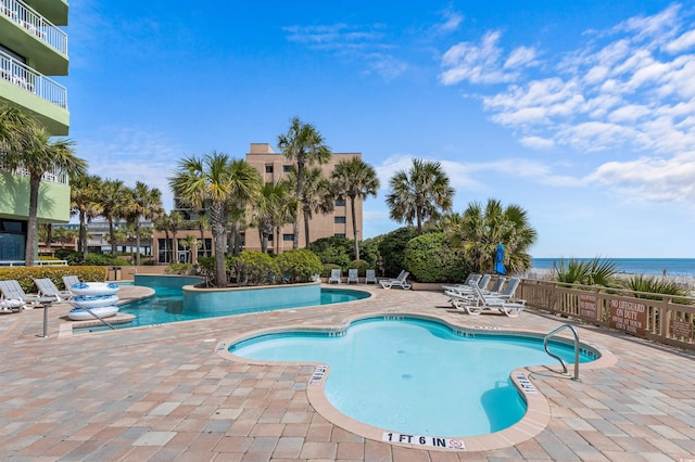 view of pool featuring a patio and a water view