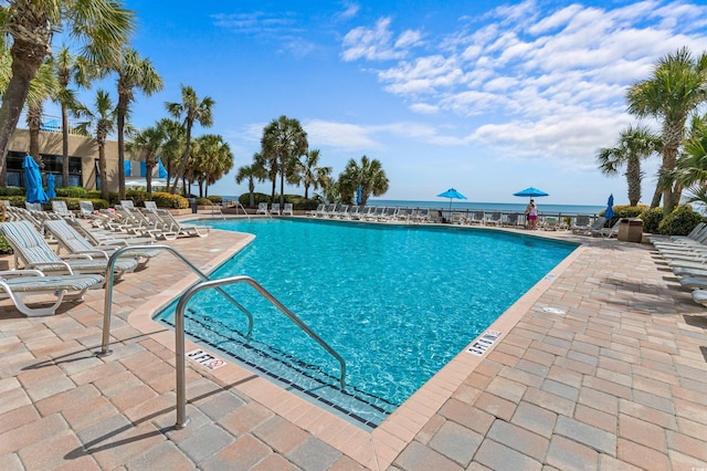 view of pool with a patio area and a water view