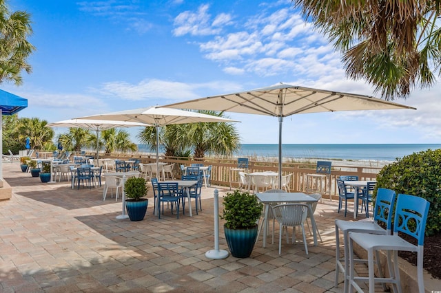 view of patio / terrace with a beach view and a water view