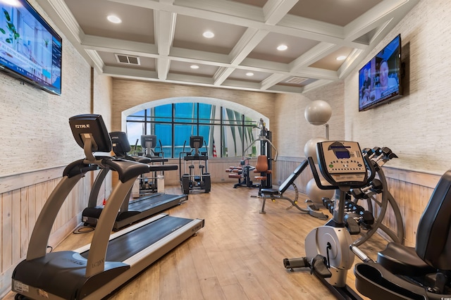 exercise room with hardwood / wood-style floors, coffered ceiling, and wooden walls