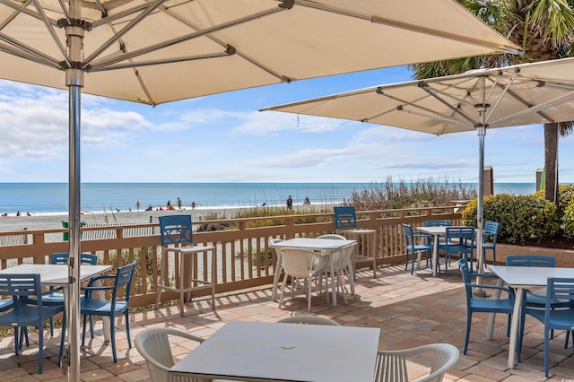 view of patio with a beach view and a water view