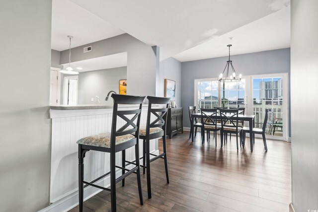 dining space with a notable chandelier and dark wood-type flooring