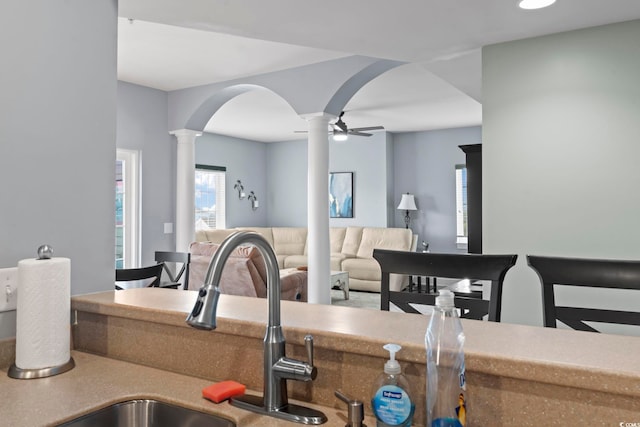 kitchen with ceiling fan, ornate columns, and sink