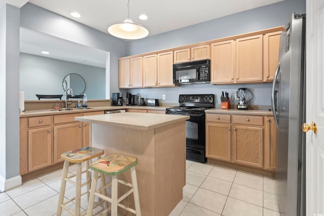 kitchen with light tile patterned flooring, black appliances, a kitchen breakfast bar, sink, and a kitchen island