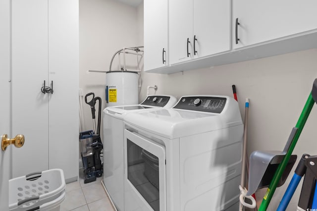 washroom with cabinets, separate washer and dryer, water heater, and light tile patterned flooring