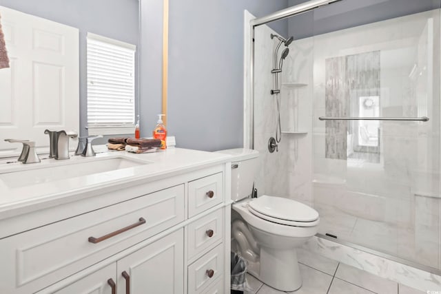 bathroom featuring tile patterned floors, vanity, a shower with shower door, and toilet