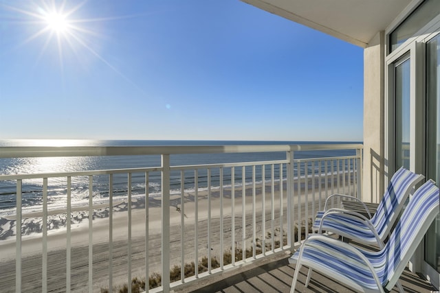 balcony featuring a beach view and a water view