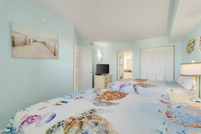 bedroom with ensuite bathroom and a closet