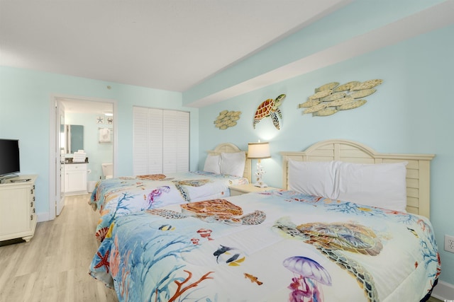 bedroom featuring ensuite bath and light hardwood / wood-style floors