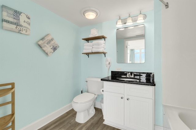 bathroom featuring vanity, hardwood / wood-style flooring, toilet, and a bathing tub