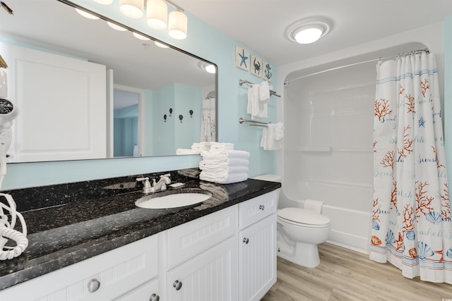 full bathroom with shower / tub combo, vanity, hardwood / wood-style flooring, and toilet