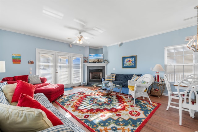 living room featuring ceiling fan, wood-type flooring, and crown molding