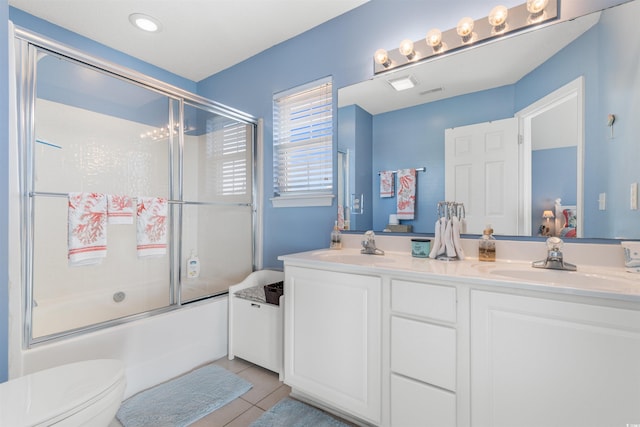 full bathroom featuring tile patterned floors, vanity, toilet, and combined bath / shower with glass door