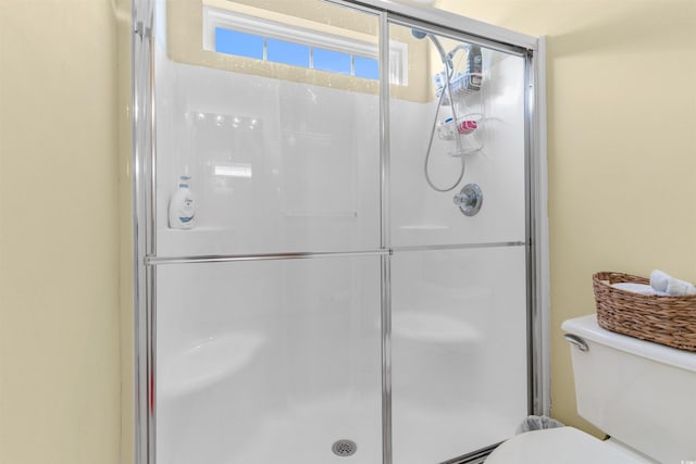 bathroom featuring toilet and an enclosed shower