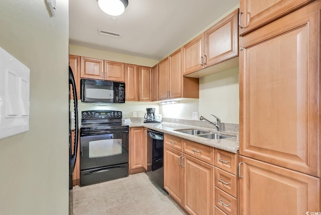 8121 Amalfi Pl Unit 5-103, Myrtle Beach, SC 29572 - kitchen with black appliances, a sink, light brown cabinetry, light tile patterned flooring, and light stone counters
