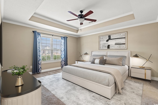 bedroom with ceiling fan, ornamental molding, and a tray ceiling