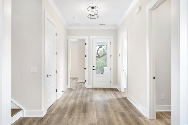 entryway with ornamental molding and light wood-type flooring