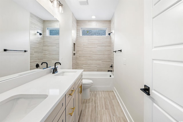 full bathroom with vanity, tiled shower / bath, and toilet