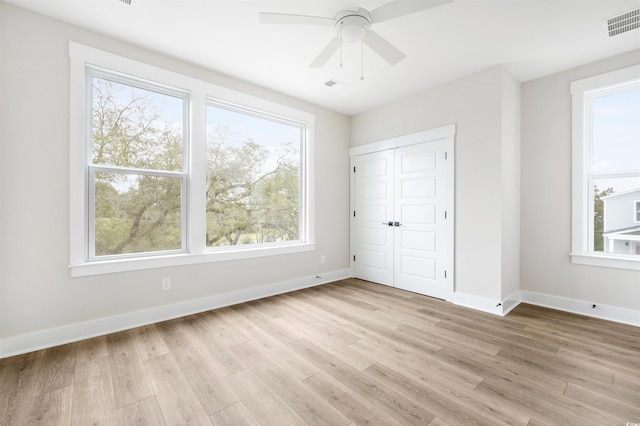 unfurnished bedroom with ceiling fan, light hardwood / wood-style floors, and a closet