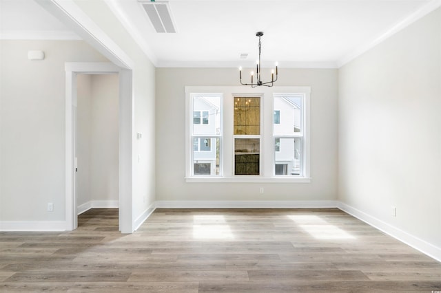 unfurnished dining area featuring ornamental molding, a chandelier, and light wood-type flooring