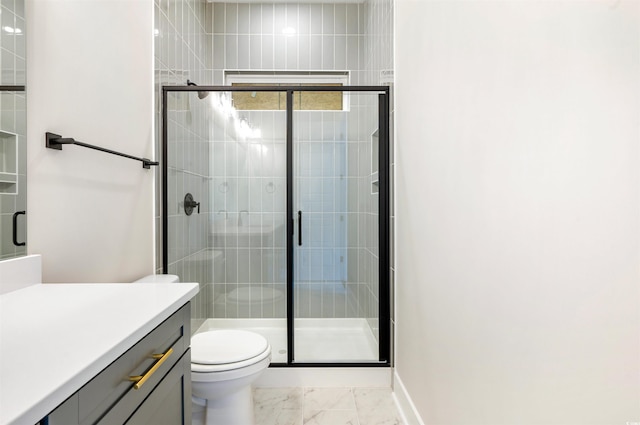 bathroom featuring a shower with door, vanity, and toilet