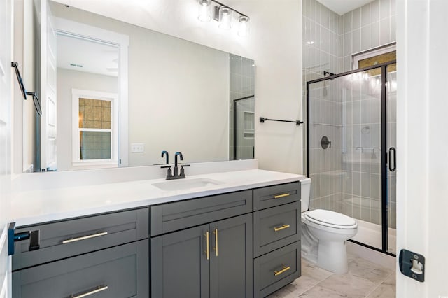 bathroom featuring vanity, an enclosed shower, and toilet