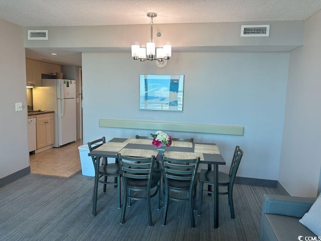 carpeted dining space with a textured ceiling and a notable chandelier