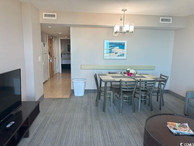 dining room with carpet flooring, a textured ceiling, and a notable chandelier