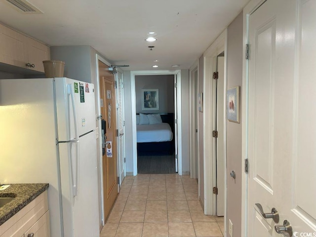 2301 S Ocean Blvd Unit 1002, North Myrtle Beach, SC 29582 - kitchen with freestanding refrigerator, light tile patterned flooring, recessed lighting, ceiling fan, and dark stone counters