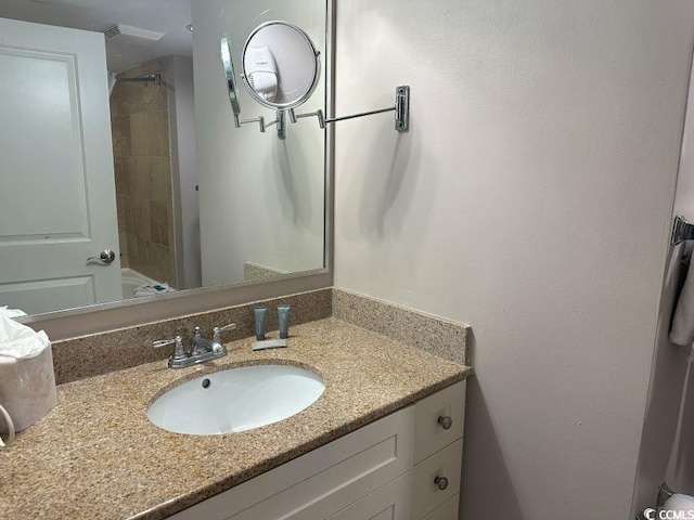 bathroom featuring vanity and tiled shower / bath