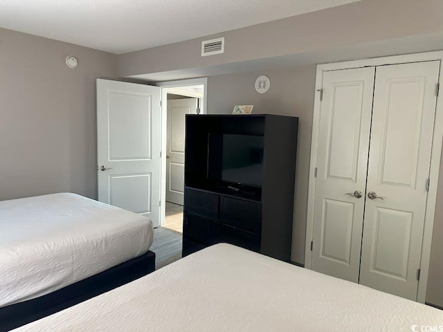 bedroom with hardwood / wood-style floors and a closet