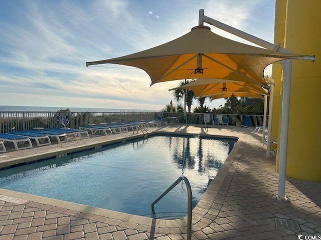 view of swimming pool featuring a patio area and a water view