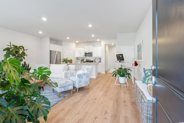 living room with light wood-type flooring and sink