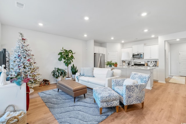 living room with sink and light hardwood / wood-style flooring