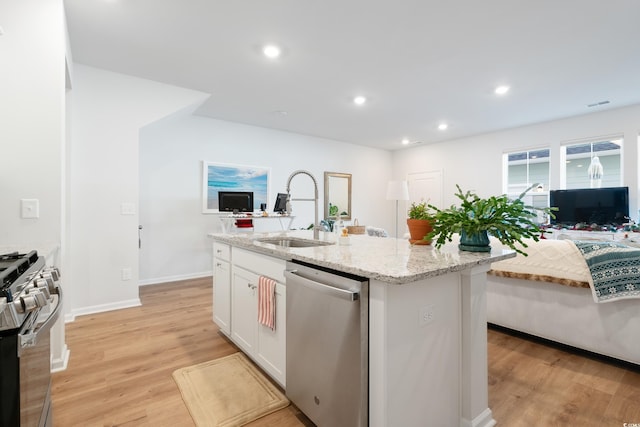 kitchen with a kitchen island with sink, sink, light stone counters, white cabinetry, and stainless steel appliances