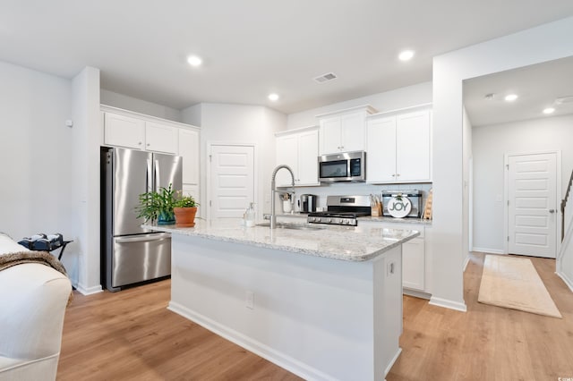 kitchen with white cabinetry, a center island with sink, stainless steel appliances, and sink