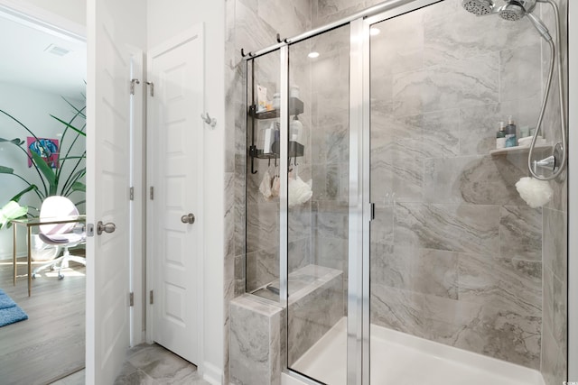 bathroom with a shower with door