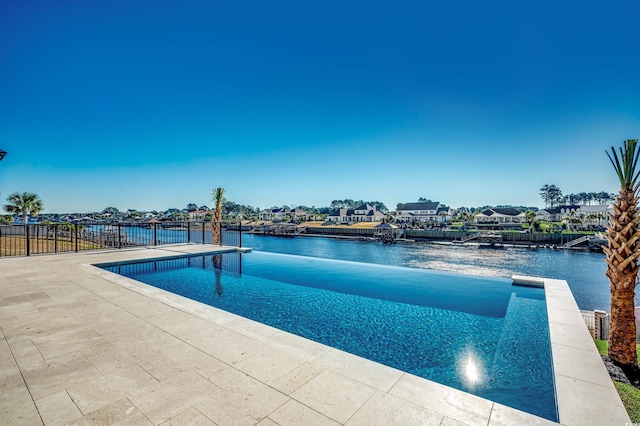 view of pool with a water view and a patio area