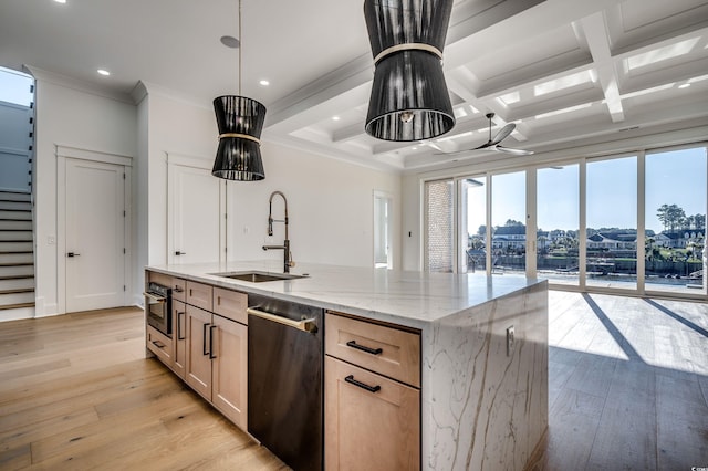 kitchen with coffered ceiling, a kitchen island with sink, light brown cabinetry, light stone countertops, and sink