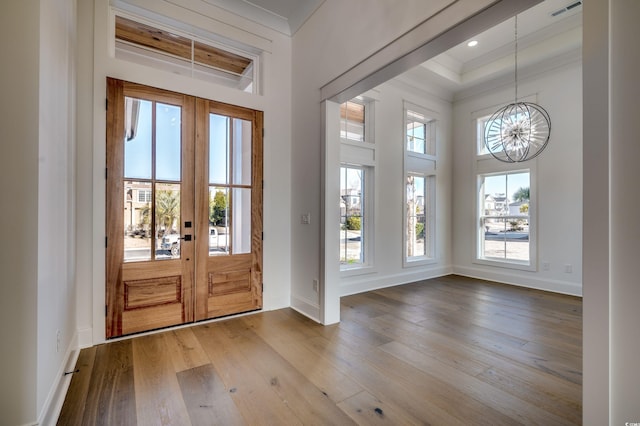 foyer featuring an inviting chandelier, a healthy amount of sunlight, and french doors