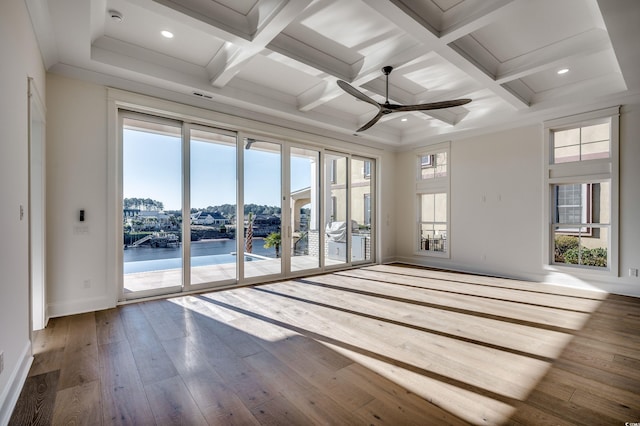 spare room featuring ceiling fan, a wealth of natural light, a water view, and hardwood / wood-style floors