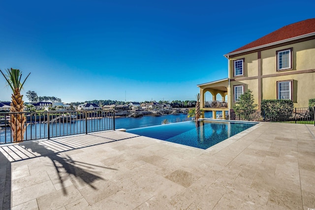 view of swimming pool featuring a water view and a patio