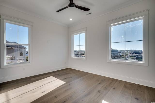 empty room with hardwood / wood-style flooring, ornamental molding, and ceiling fan