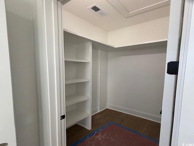 walk in closet with dark wood-type flooring